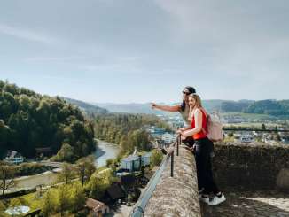 Zwei Frauen schauen von der Terrasse des Schloss Burgdorf hinunter auf die Stadt und zeigen, was sie sehen. Im Hintergrund ist die Emme zu sehen.
